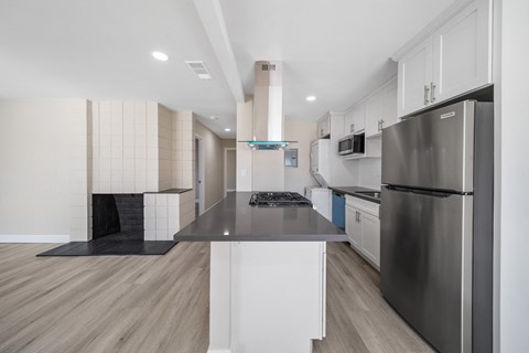 a renovated kitchen with stainless steel appliances and white cabinets